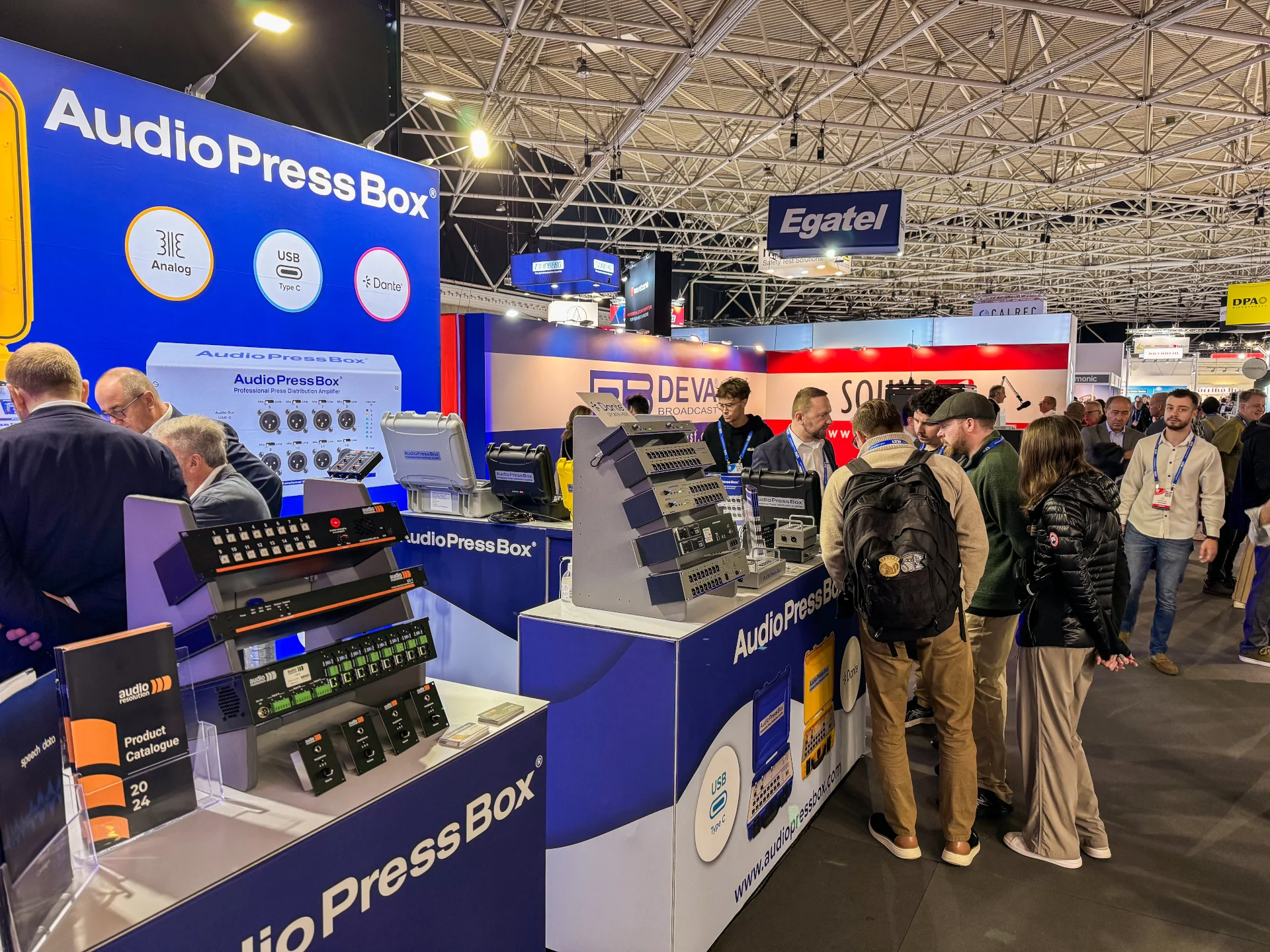 IBC-2024 - AudioPressBox trade show booth demonstration — visitors discussing press box audio distribution