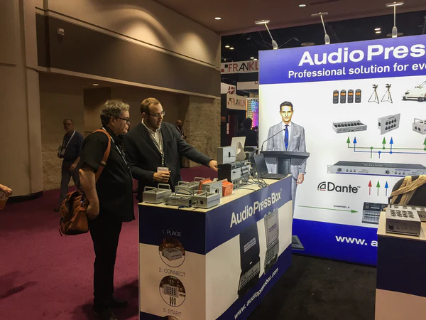 InfoComm 2019 AudioPressBox trade show booth demonstration — visitors discussing press box audio distribution