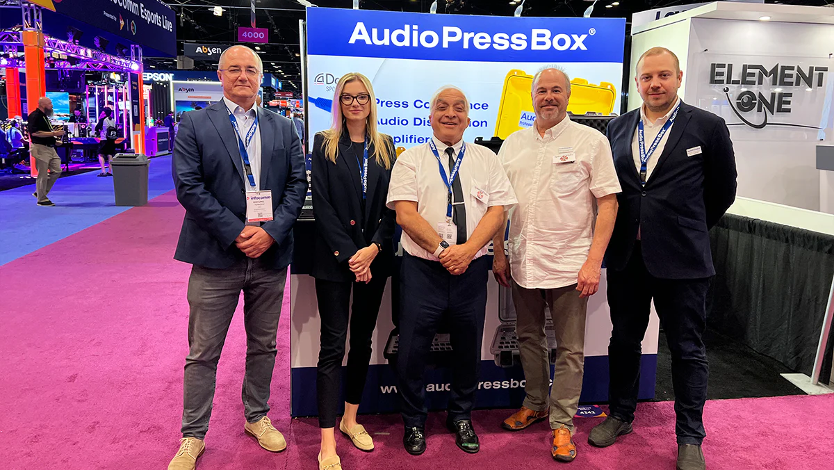 InfoComm 2024 - AudioPressBox trade show booth demonstration — visitors discussing press box audio distribution